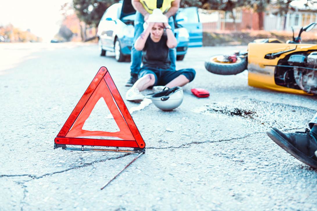 A person sitting on the ground next to a broken motorcycle

AI-generated content may be incorrect.